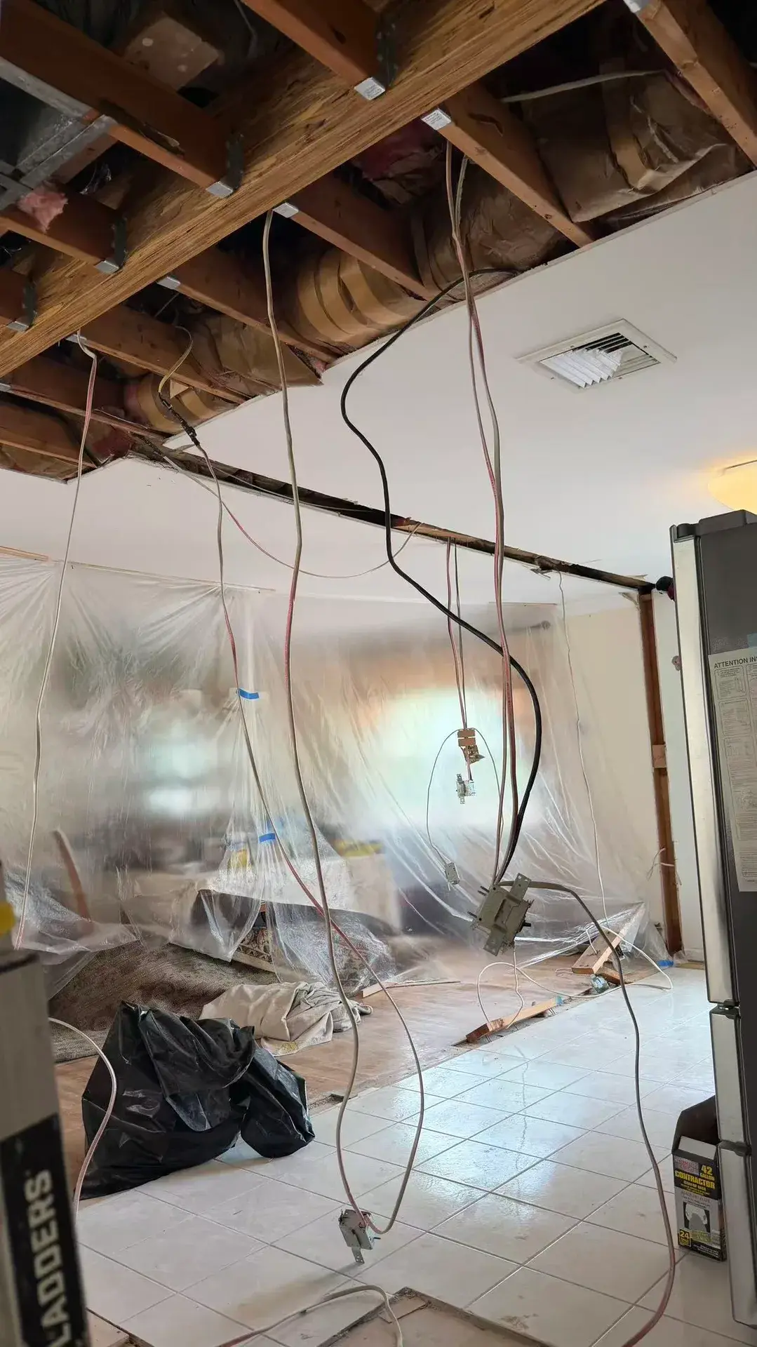 Ceiling opened for new wiring, with plastic sheeting protecting the rest of the house