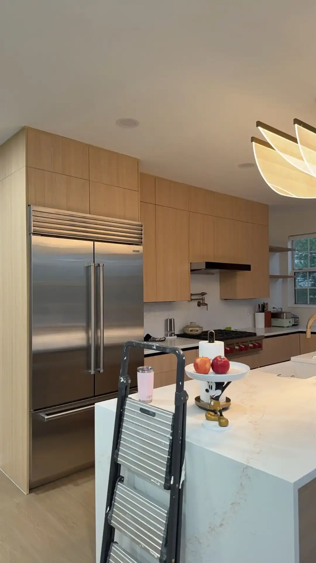 Modern kitchen with flat-panel wood cabinets and a waterfall quartz island